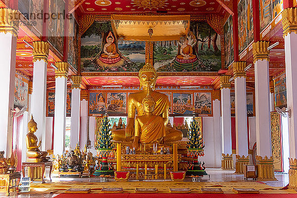 Wat Si Saket  eine große goldene Buddhastatue und Altar mit Opfergaben und Wandmalereien  Vientiane  Laos