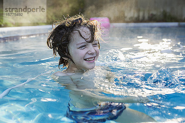Ein sechsjähriger Junge schwimmt in einem warmen Pool.