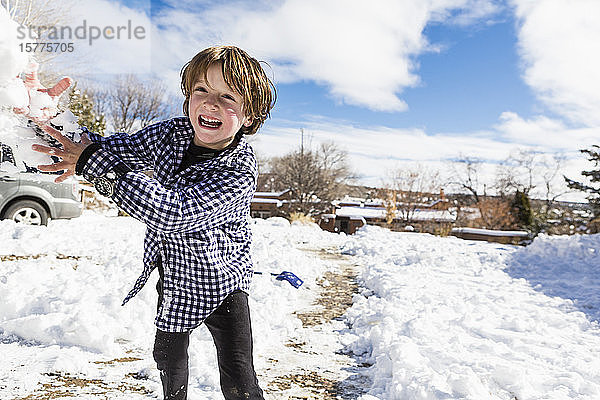 Ein kleiner Junge wirft einen Schneeball