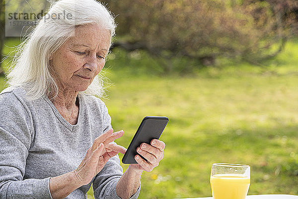 Ältere Frau benutzt ein Smartphone