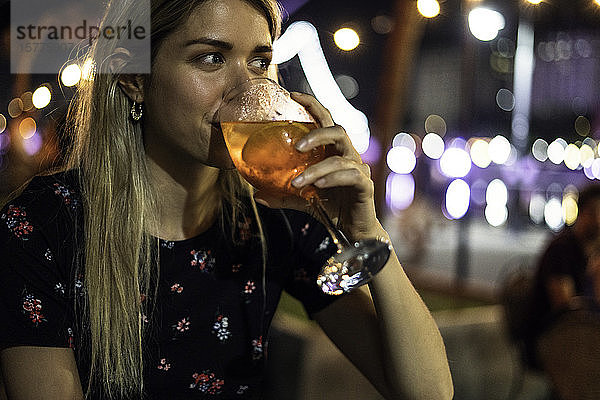 Junge Frau trinkt Cocktail