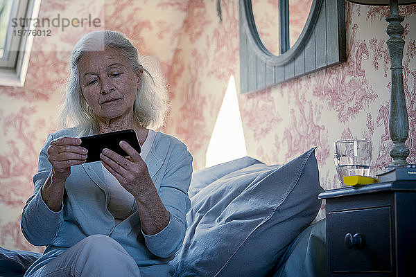Ältere Frau schaut Video auf Smartphone