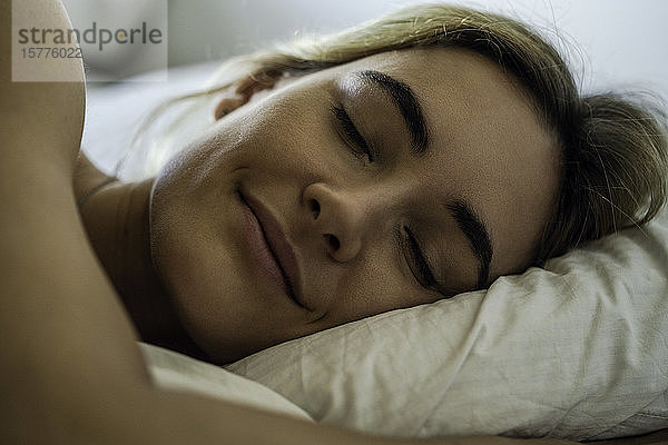 Junge Frau schläft auf dem Bett