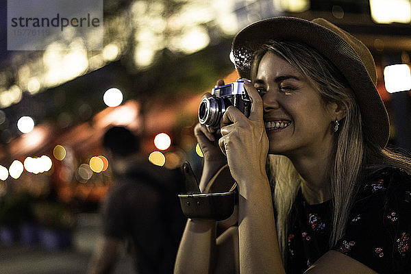 Junge Frau fotografiert mit Kamera
