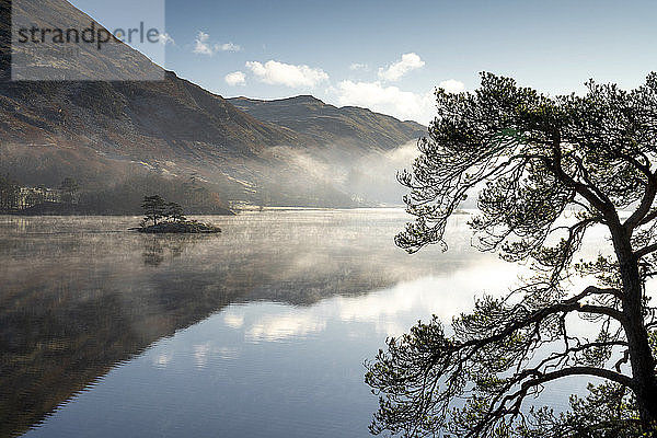 Dämmerungslicht und vorübergehender Sonnennebel über Wall Holm Island auf Ullswater  Lake District National Park  UNESCO-Weltkulturerbe  Cumbria  England  Vereinigtes Königreich  Europa