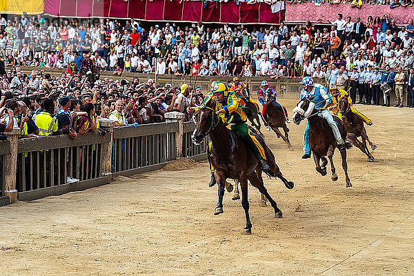 Jockeys in farbenfrohen Kostümen  die ihre jeweiligen Stadtviertel repräsentieren  in voller Fahrt beim Palio  einem Pferderennen ohne Sattel  Siena  Toskana  Italien  Europa
