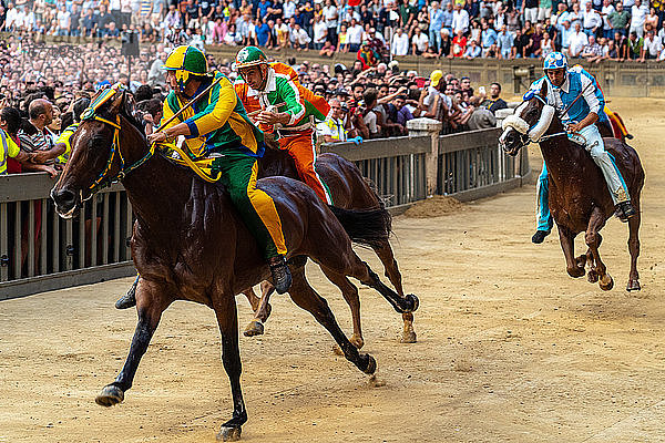 Jockeys in farbenfrohen Kostümen  die ihre jeweiligen Stadtviertel (contrade) repräsentieren  wetteifern um die Führung beim Palio  Siena  Toskana  Italien  Europa