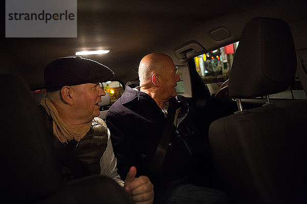 Schwules Paar  das nachts im Auto sitzt und durch das Fenster schaut