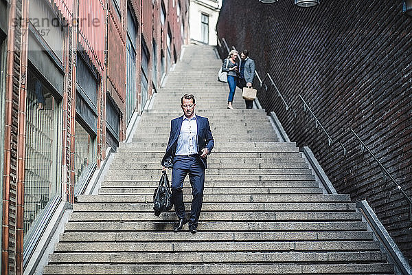 Reifer männlicher Unternehmer beim Treppensteigen