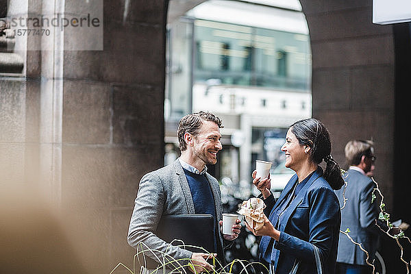 Glückliche Geschäftsleute mit Kaffee im Straßencafé