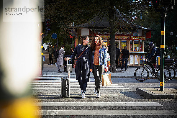 Frauen mit Taschen in voller Länge auf Zebrastreifen in der Stadt