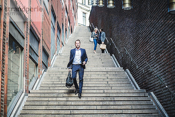 Porträt eines reifen Geschäftsmannes beim Treppensteigen