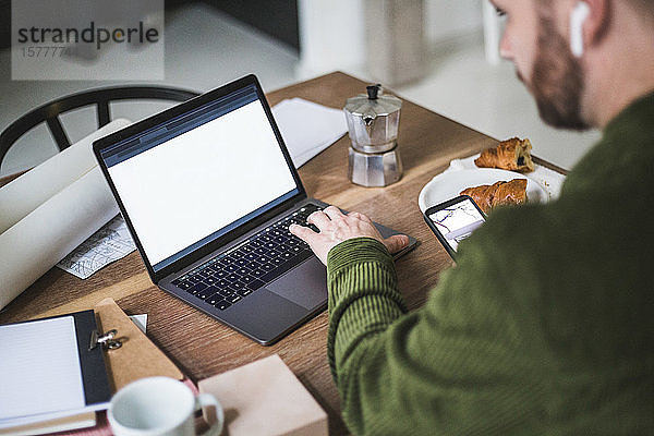 Unternehmer mit Laptop im Heimbüro