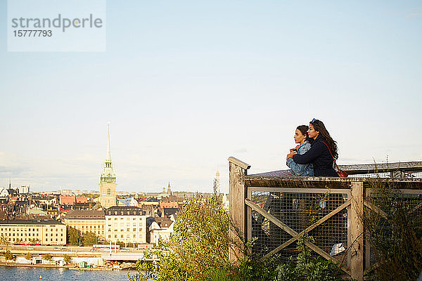 Seitenansicht eines lesbischen Paares  das am Beobachtungspunkt am Stadtbild gegen den Himmel steht