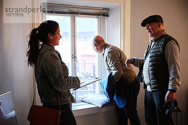 Älterer Mann spricht mit Eigentümerin  während er mit Freundin zu Hause steht
