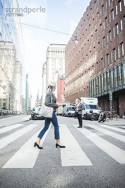 Geschäftsfrau überquert Straße in der Stadt