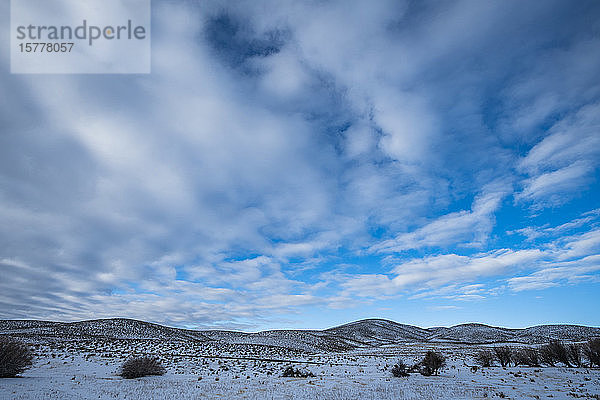 Verschneite Hügel unter Wolken