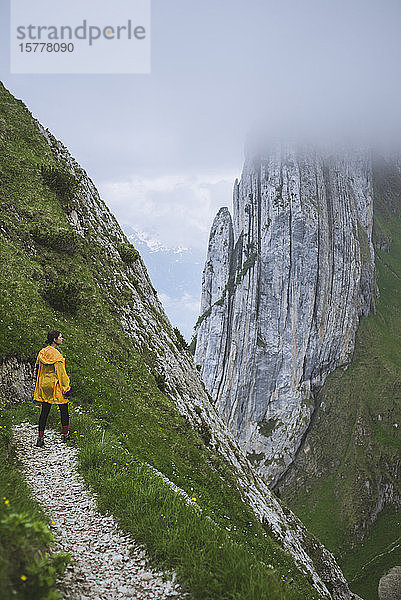 Frau mit gelber Jacke auf einem Berg in Appenzell  Schweiz