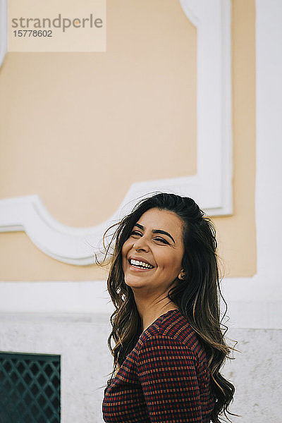 Lächelnde Frau an der Wand