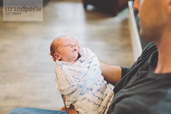 Vater hält neugeborenen Jungen