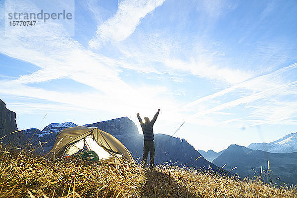 Wanderer begrüßt den Sonnenaufgang auf dem Berggipfel  Canazei  Trentino-Südtirol  Italien