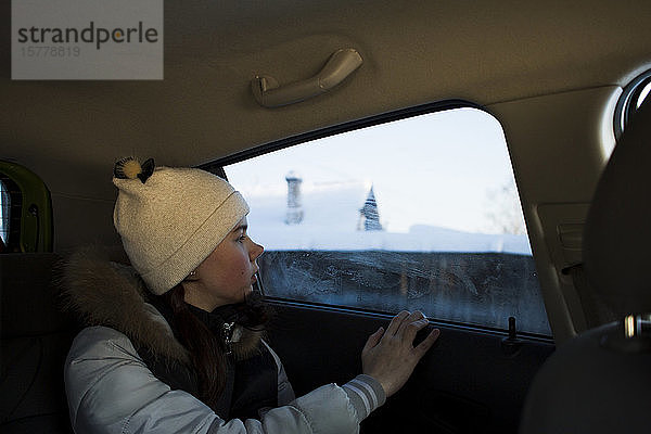 Mädchen schaut aus dem Autofenster