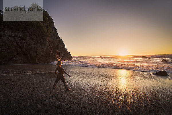 Junge steht am Strand und schaut auf Sonnenuntergang  Kaikoura  Gisborne  Neuseeland