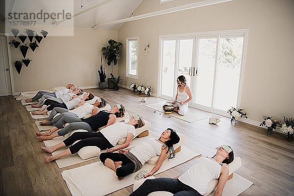 Frauen in Entspannungsstellung posieren nach Yoga-Unterricht auf Rückzug