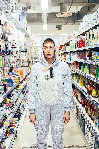 Porträt einer Frau im Erwachsenen-Bodysuit auf der Supermarkt-Insel  die in die Kamera schaut