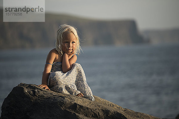 Porträt eines jungen Mädchens  auf einem Felsen sitzend  Doolin  Clare  Irland