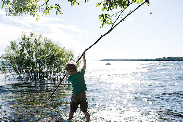 Junge erforscht Wasser mit dem Stock  Kingston  Kanada