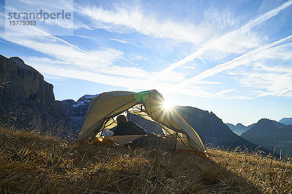Wanderer erwacht im Zelt auf dem Berggipfel  Canazei  Trentino-Südtirol  Italien