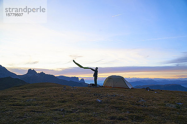 Wanderer  der sich auf ein Lager bei Sonnenuntergang vorbereitet  Canazei  Trentino-Südtirol  Italien