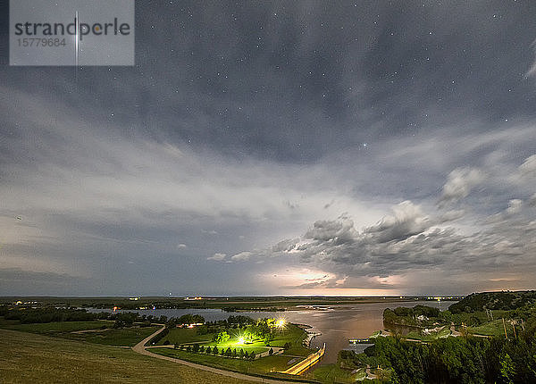 In der Ferne tobt ein Gewitter  während ein Satellit mit seinen Sonnenkollektoren über dem ländlichen Nebraska   USA