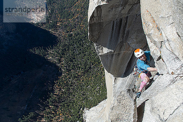 Hochwinkelaufnahme eines Bergsteigers  der die steile Wand von The Nose  El Capitan  Yosemite National Park hinaufklettert.