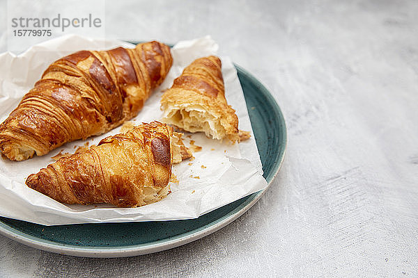 Teller mit Croissants  ganz und in der Hälfte zerbrochen