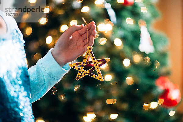 Person hält Weihnachtsschmuck  Stern aus Eisstielen