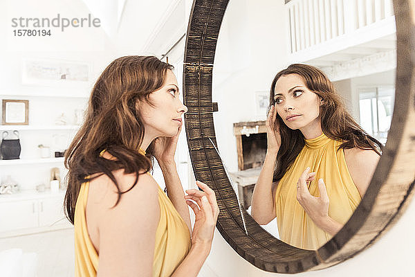 Brünette Frau im Abendkleid mit Blick in den Spiegel