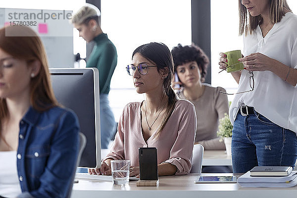 Geschäftsfrau  die am Computer in einem Büro arbeitet  der Chef steht neben ihr