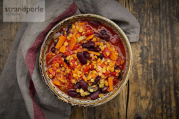 Schale mit veganem Chili mit roten Linsen  Selleriestangen  Kidneybohnen  Tomaten und Karotten