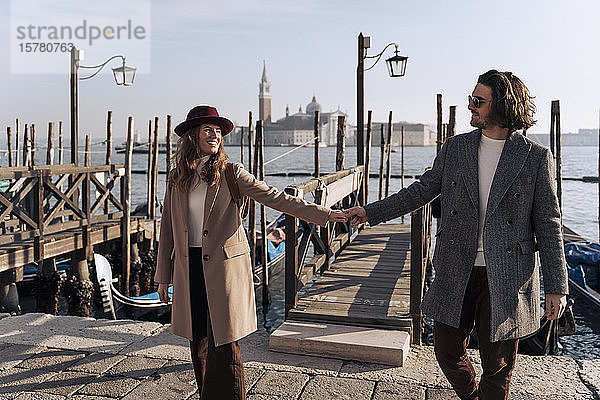 Junges Paar geht Hand in Hand an der Uferpromenade von Venedig  Italien