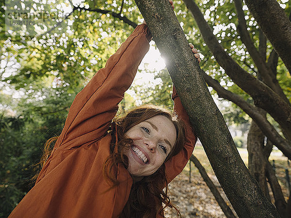 Glückliche rothaarige Frau genießt den Herbst in einem Park