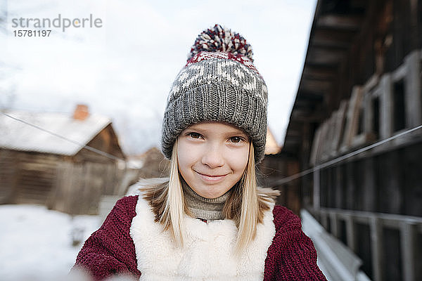 Porträt eines lächelnden Mädchens mit Wollmütze im Winter