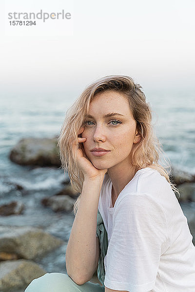 Junge Frau verbringt einen Tag am Meer  sitzt am Strand