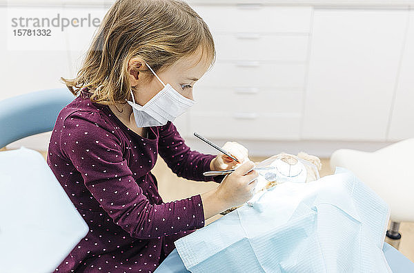 Mädchen beim Zahnarzt untersucht Teddybär