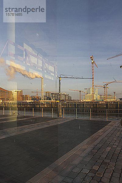 Deutschland  Hamburg  HafenCity-Hafen im Morgengrauen mit Rauch aus Industrieschornsteinen im Hintergrund