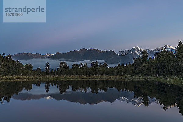 Neuseeland  Westland-Distrikt  Fox-Gletscher  Gebirgskette  die sich in der Morgendämmerung im Lake Matheson spiegelt