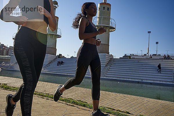 Zwei Sportlerinnen joggen an einem See in der Stadt  Barcelona  Spanien