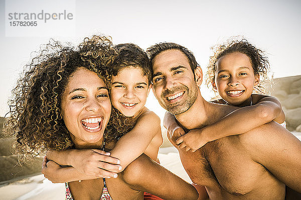 Porträt einer glücklichen Familie  die sich am Strand amüsiert