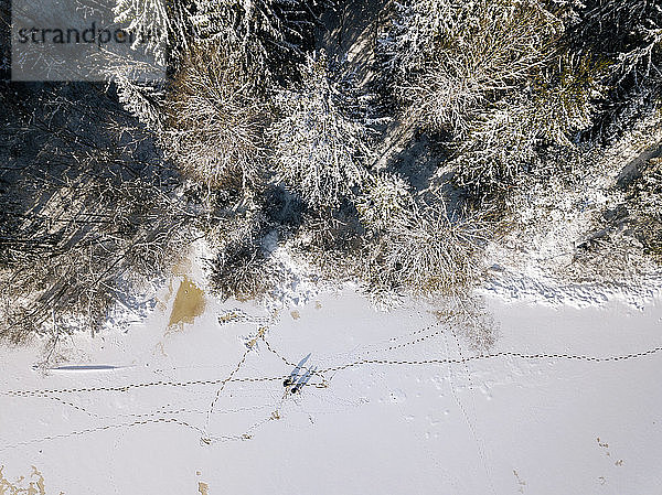 Russland  Oblast Leningrad  Tichwin  Luftaufnahme von zwei Männern  die an der gefrorenen Küste fischen